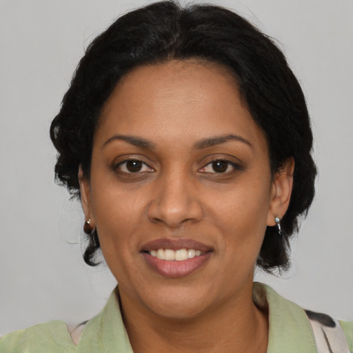 Joyful black adult female with medium  black hair and brown eyes