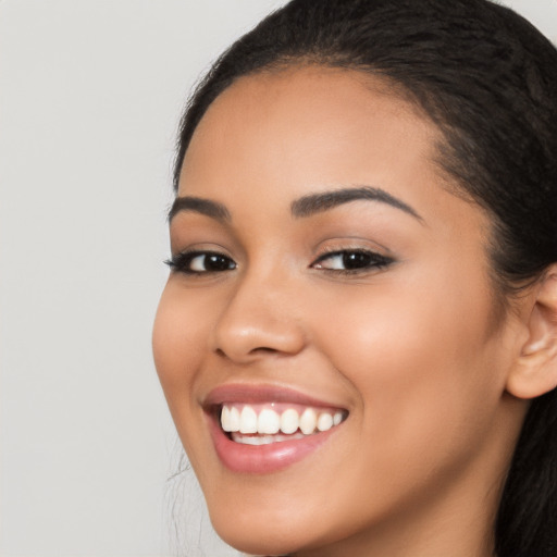 Joyful latino young-adult female with long  brown hair and brown eyes