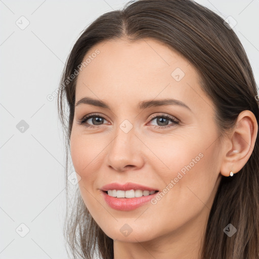 Joyful white young-adult female with long  brown hair and brown eyes