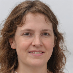 Joyful white adult female with medium  brown hair and grey eyes