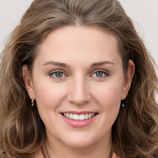 Joyful white young-adult female with long  brown hair and grey eyes