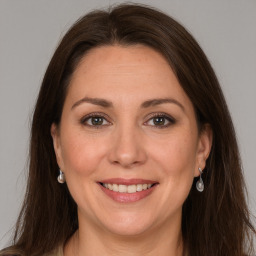 Joyful white adult female with long  brown hair and grey eyes