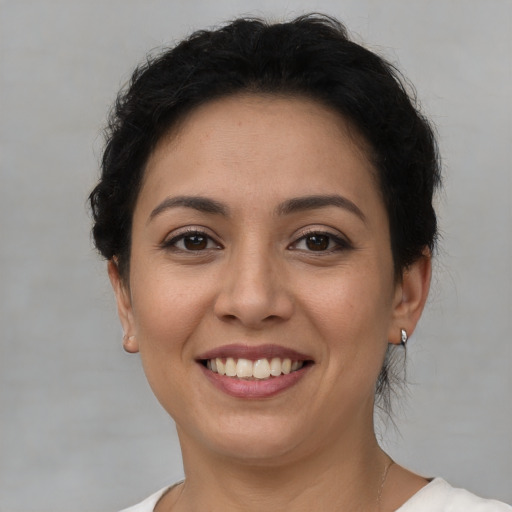 Joyful latino young-adult female with short  brown hair and brown eyes
