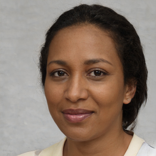 Joyful black young-adult female with medium  brown hair and brown eyes