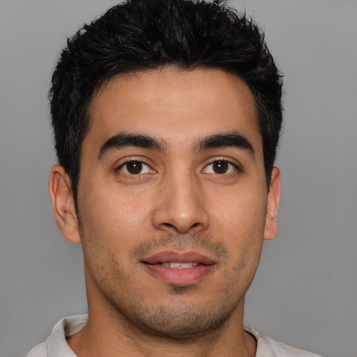 Joyful latino young-adult male with short  black hair and brown eyes
