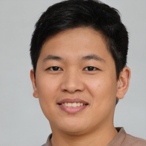 Joyful asian young-adult male with short  brown hair and brown eyes