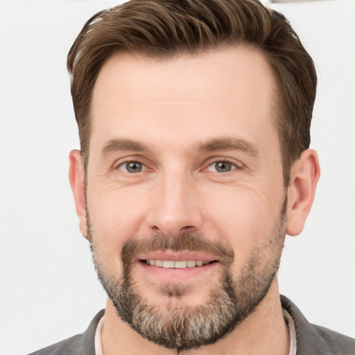 Joyful white adult male with short  brown hair and grey eyes