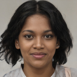 Joyful black young-adult female with medium  brown hair and brown eyes