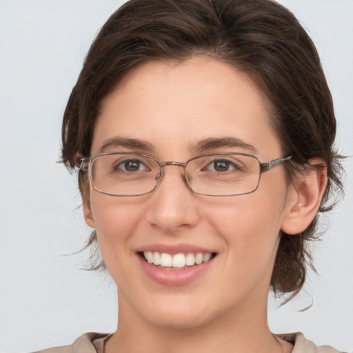 Joyful white young-adult female with medium  brown hair and grey eyes