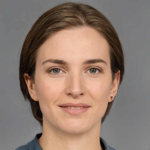 Joyful white young-adult female with medium  brown hair and grey eyes