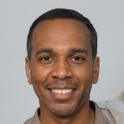 Joyful black adult male with short  black hair and brown eyes