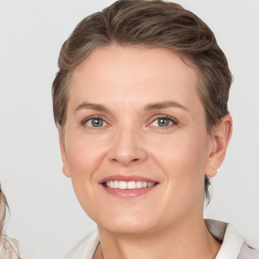 Joyful white young-adult female with medium  brown hair and grey eyes