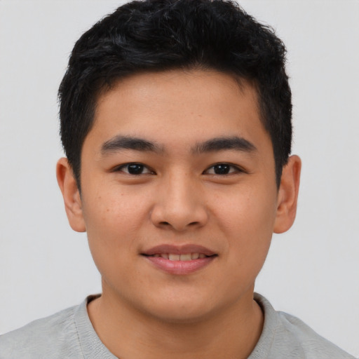 Joyful asian young-adult male with short  brown hair and brown eyes