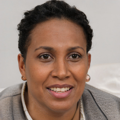 Joyful black adult female with short  brown hair and brown eyes