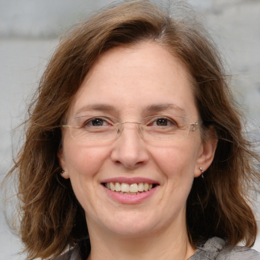 Joyful white adult female with medium  brown hair and blue eyes