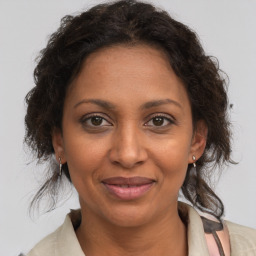 Joyful black adult female with medium  brown hair and brown eyes