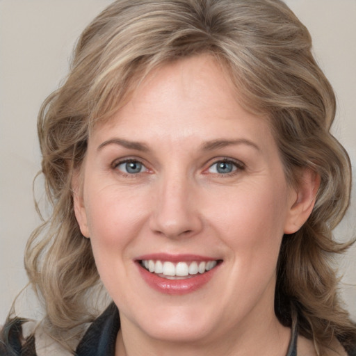 Joyful white adult female with medium  brown hair and grey eyes