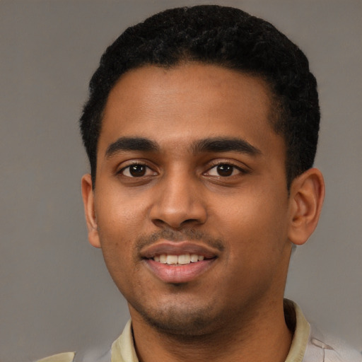 Joyful black young-adult male with short  black hair and brown eyes