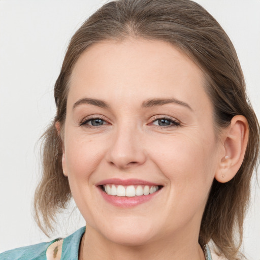 Joyful white young-adult female with medium  brown hair and grey eyes