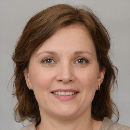 Joyful white adult female with medium  brown hair and grey eyes