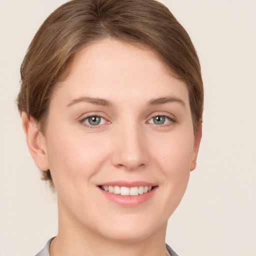 Joyful white young-adult female with short  brown hair and grey eyes