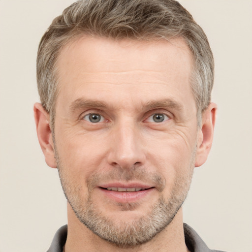 Joyful white adult male with short  brown hair and grey eyes