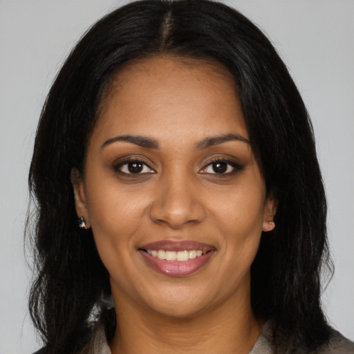 Joyful black young-adult female with long  black hair and brown eyes
