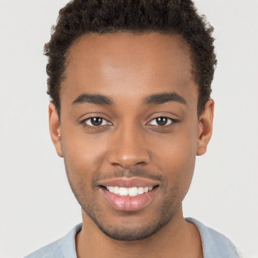 Joyful black young-adult male with short  brown hair and brown eyes