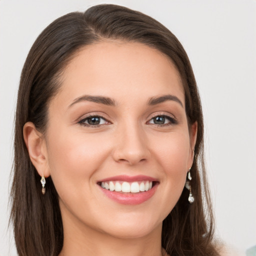 Joyful white young-adult female with long  brown hair and grey eyes