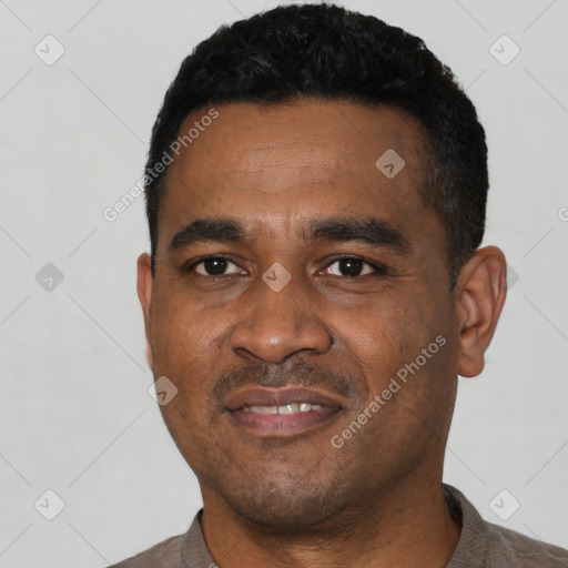 Joyful black young-adult male with short  black hair and brown eyes