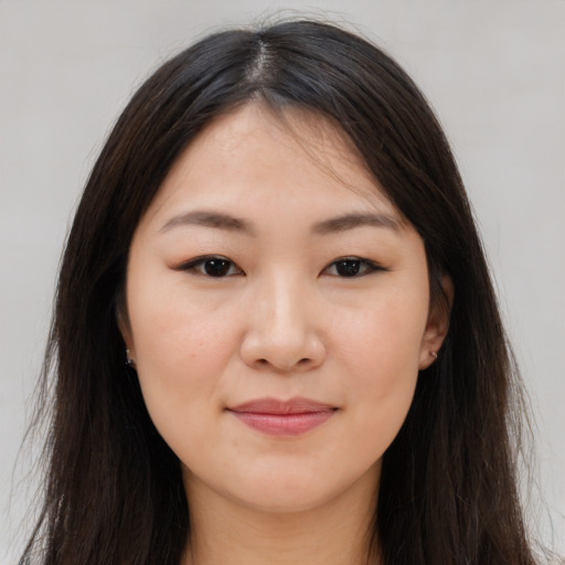 Joyful asian young-adult female with long  brown hair and brown eyes