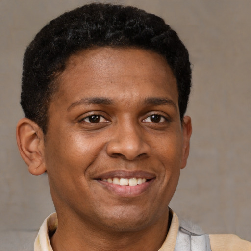 Joyful latino young-adult male with short  brown hair and brown eyes
