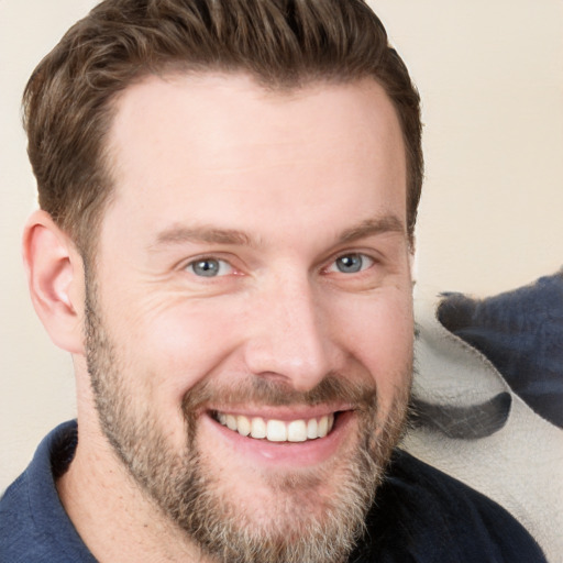 Joyful white young-adult male with short  brown hair and blue eyes