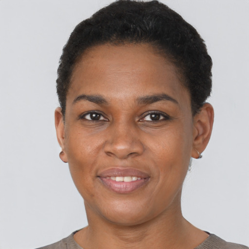 Joyful black young-adult female with short  black hair and brown eyes