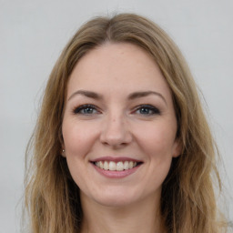 Joyful white young-adult female with long  brown hair and grey eyes