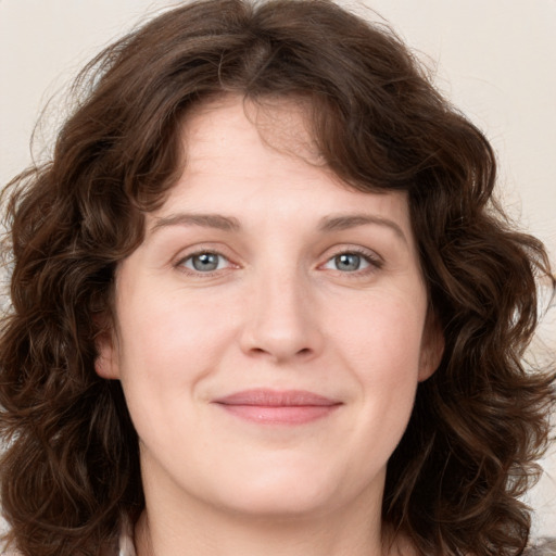 Joyful white young-adult female with medium  brown hair and green eyes