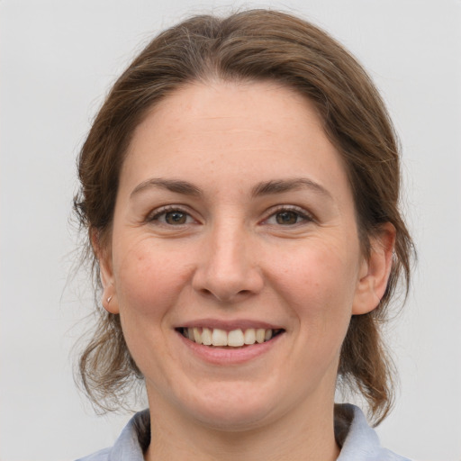 Joyful white young-adult female with medium  brown hair and grey eyes