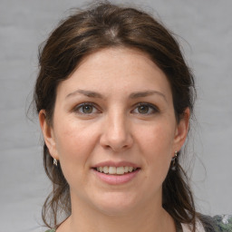 Joyful white adult female with medium  brown hair and grey eyes