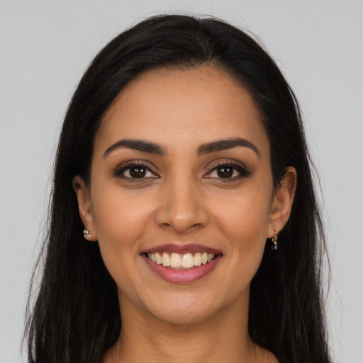 Joyful latino young-adult female with long  brown hair and brown eyes