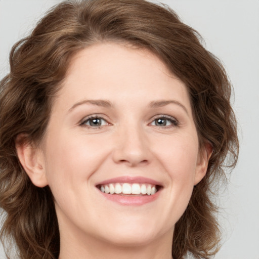 Joyful white young-adult female with medium  brown hair and blue eyes