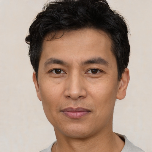 Joyful asian young-adult male with short  black hair and brown eyes