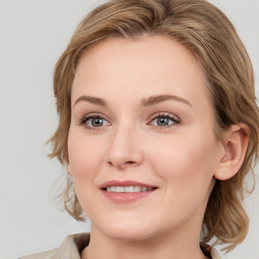 Joyful white young-adult female with medium  brown hair and blue eyes