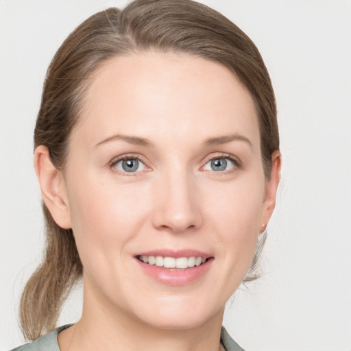 Joyful white young-adult female with medium  brown hair and grey eyes