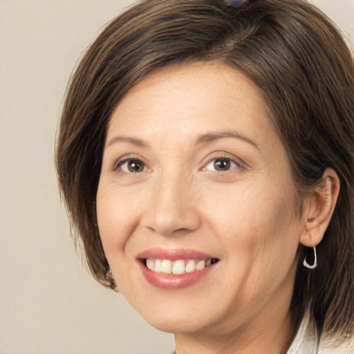 Joyful white adult female with medium  brown hair and brown eyes