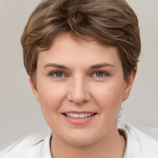 Joyful white young-adult female with short  brown hair and grey eyes