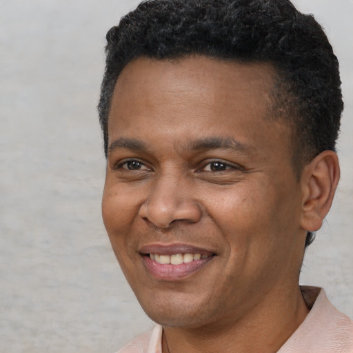 Joyful black adult male with short  brown hair and brown eyes