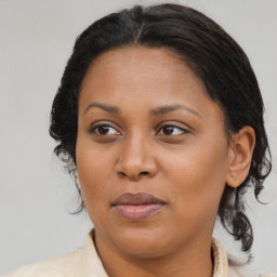 Joyful black adult female with medium  brown hair and brown eyes