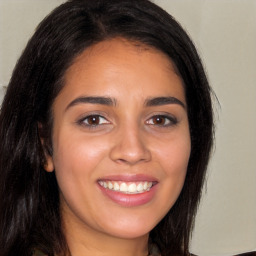 Joyful latino young-adult female with long  brown hair and brown eyes