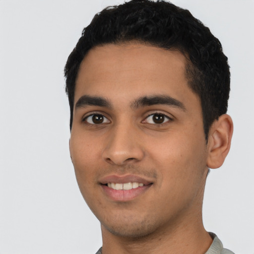 Joyful latino young-adult male with short  black hair and brown eyes