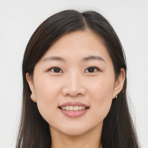 Joyful asian young-adult female with long  brown hair and brown eyes